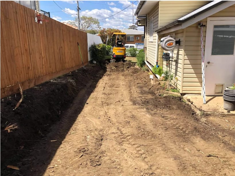 The transformation saw the construction of a long charcoal concrete sleeper retaining wall, a testament to robust engineering and aesthetic elegance