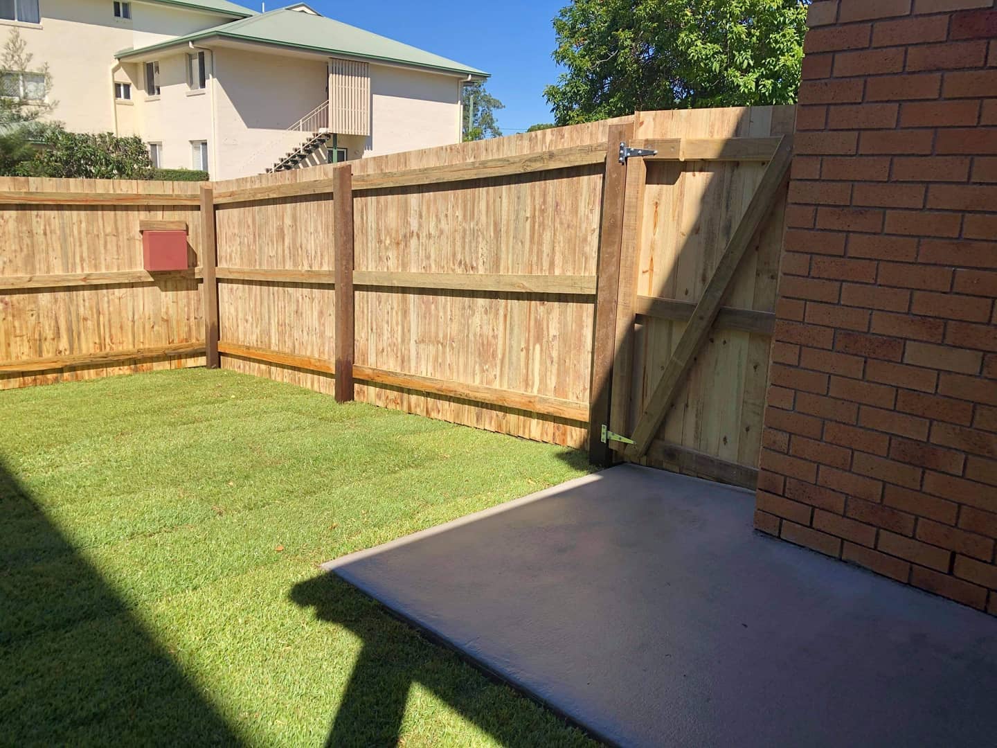 Timber fence concrete entrance stepping stones and front grass