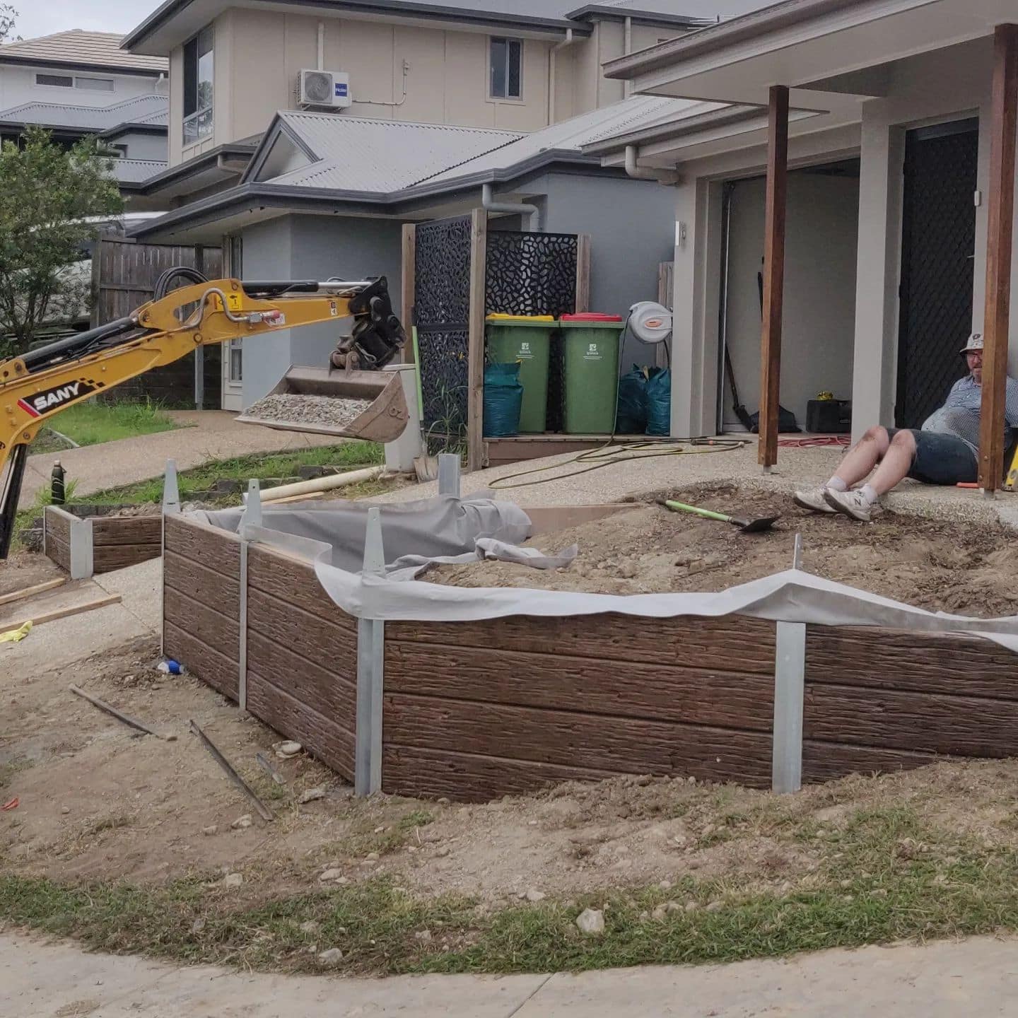 Completed drainage system installation, road base fill, and compaction with fence brackets